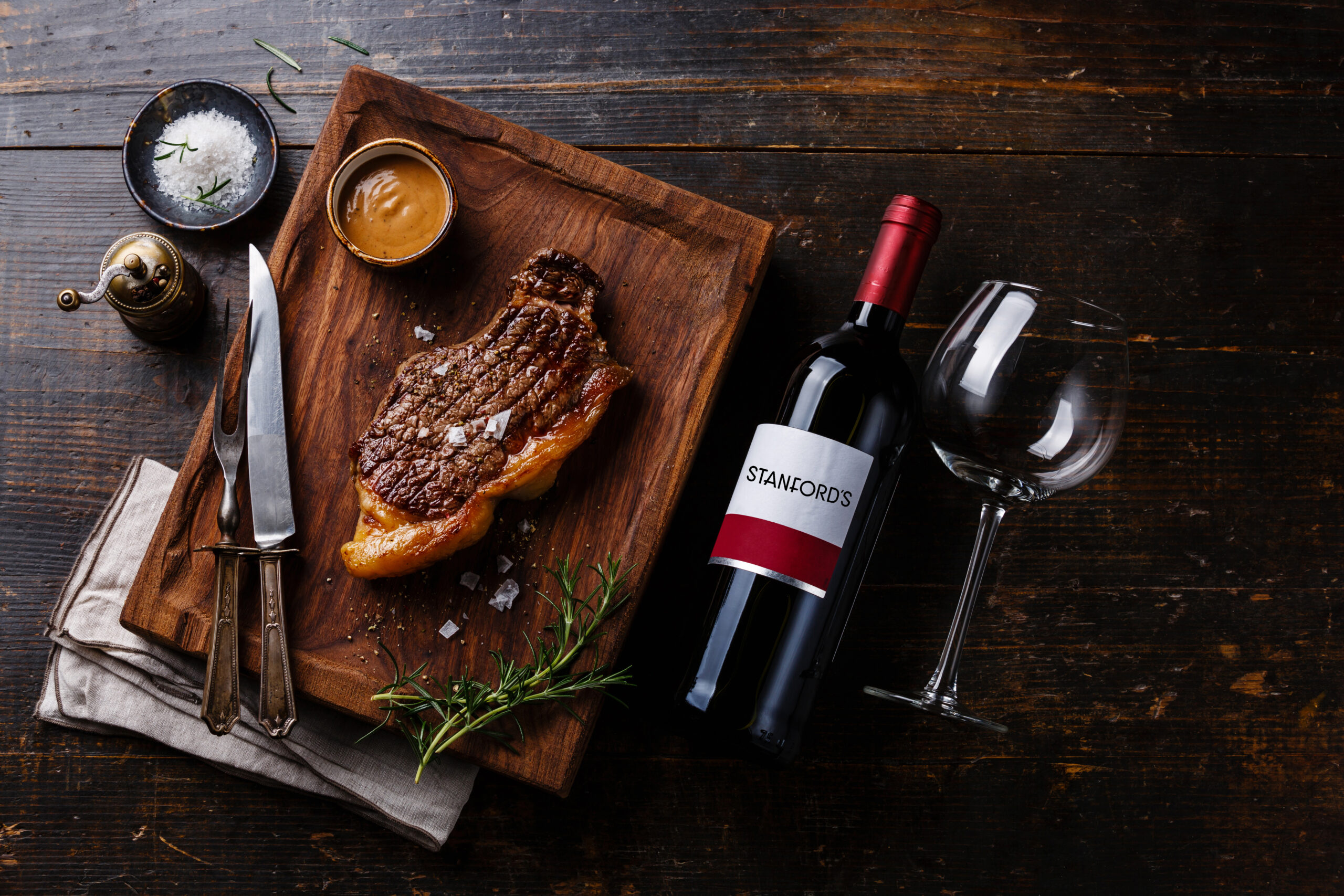 Fresh steak on cutting board with bottled wine at steakhouse in Oregon and Washington